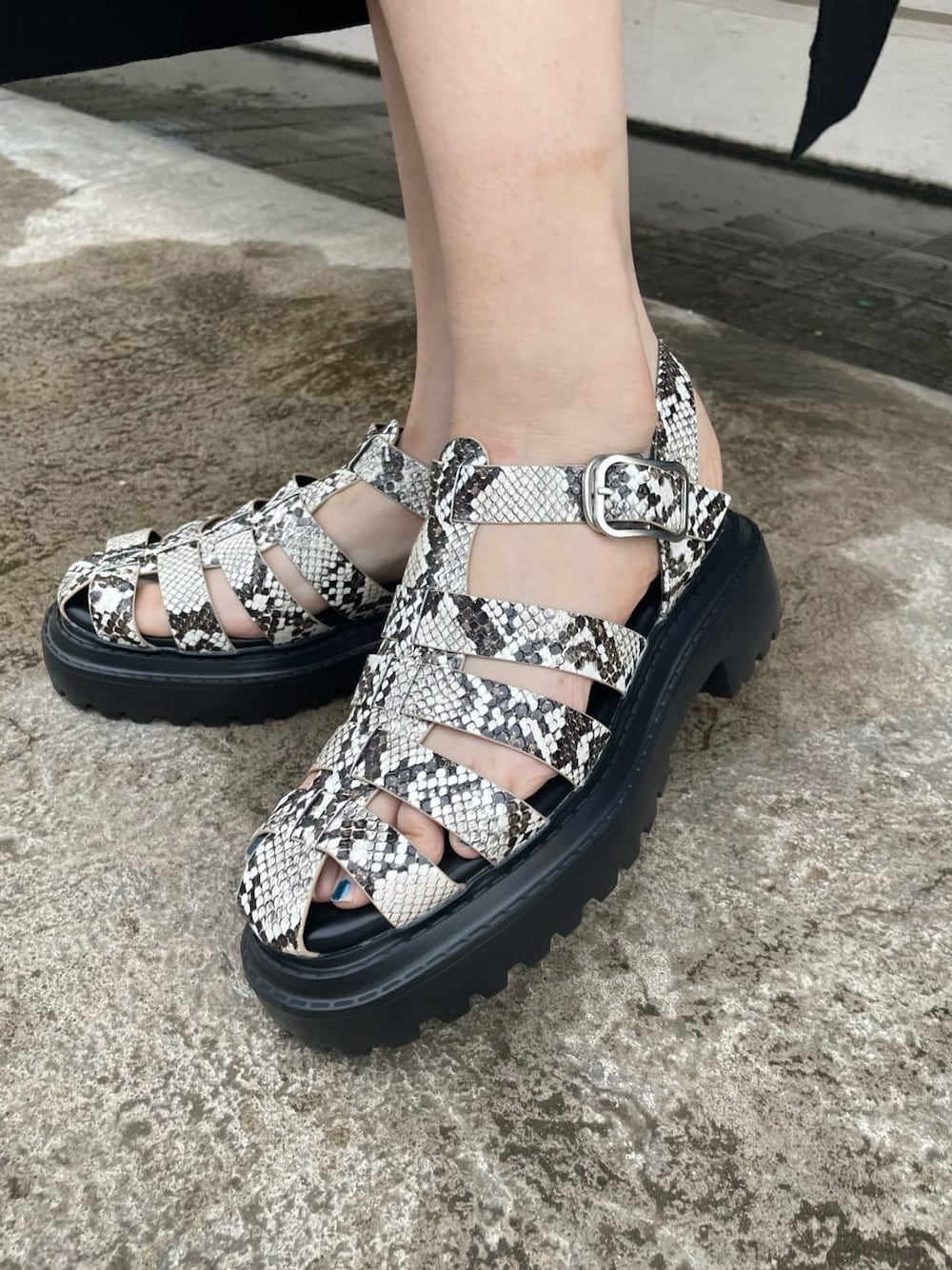 ブラック系のショルダーバッグ、その他のサンダル、ブラック系のワンピースを着用したレディースの春コーディネートの5枚目の写真