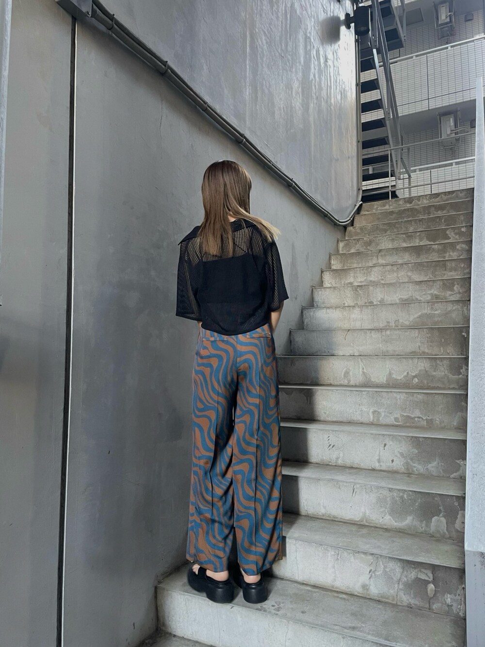 ブラック系のシャツ/ブラウス、ブラック系のサンダル、ブラック系のハンドバッグを着用したレディースの春コーディネートの3枚目の写真