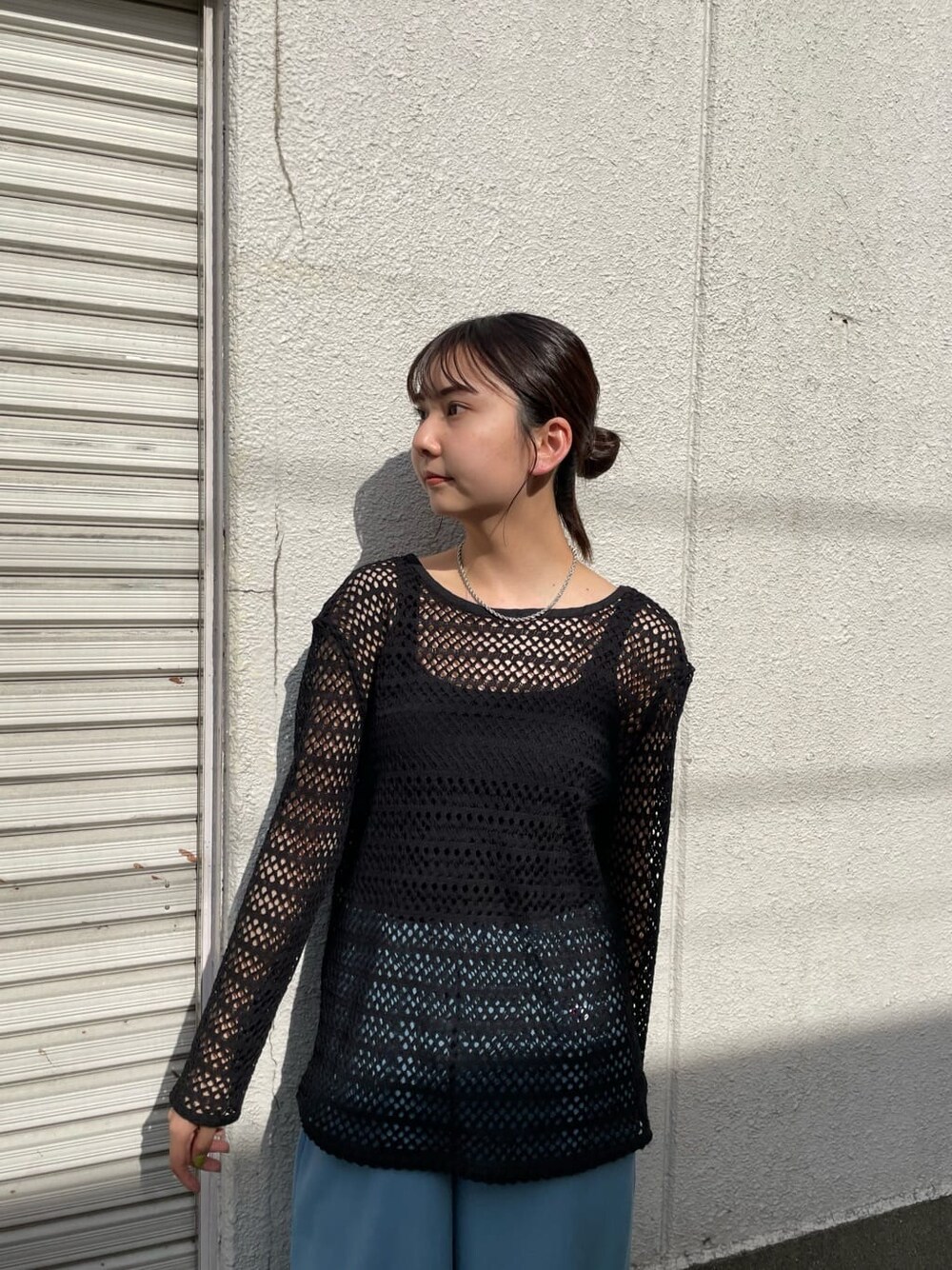 ブルー系のスウェットパンツ、ホワイト系のサンダル、ブラック系のTシャツ/カットソーを着用したレディースの春コーディネートの4枚目の写真