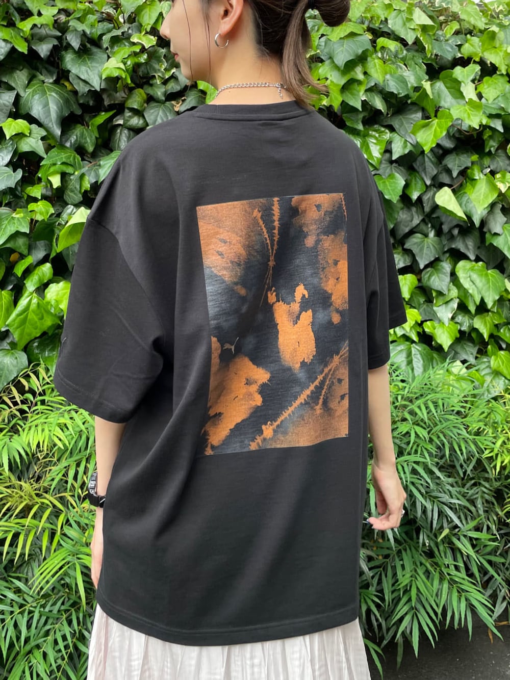 ホワイト系のスカート、ブラック系のTシャツ/カットソーを着用したレディースの春コーディネートの5枚目の写真