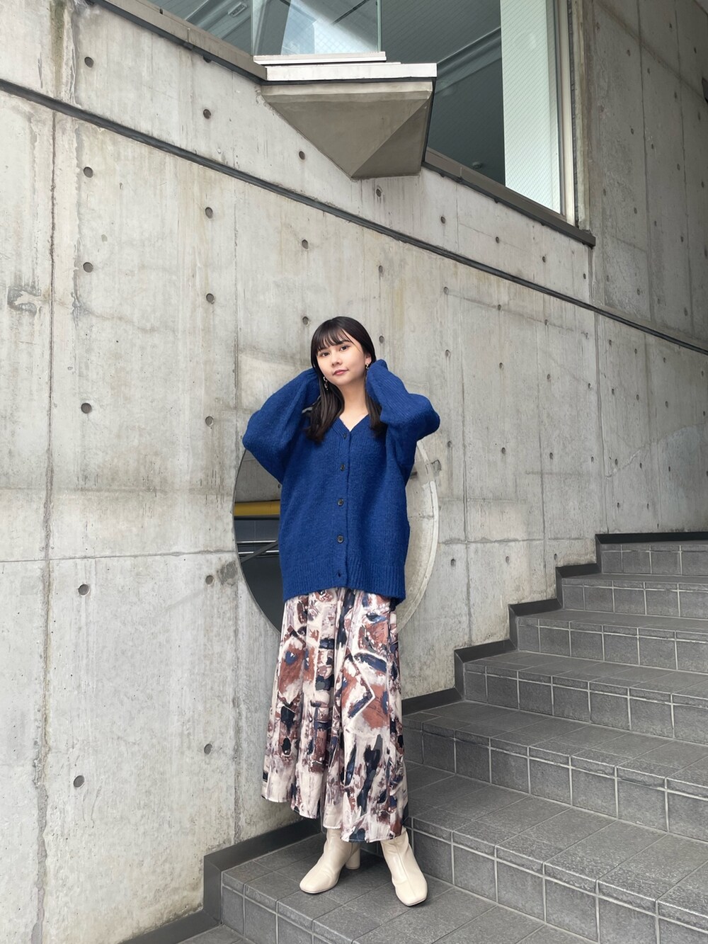 ブルー系のカーディガン/ボレロ、ブルー系のスカート、ホワイト系のブーツを着用したレディースの夏コーディネートの4枚目の写真