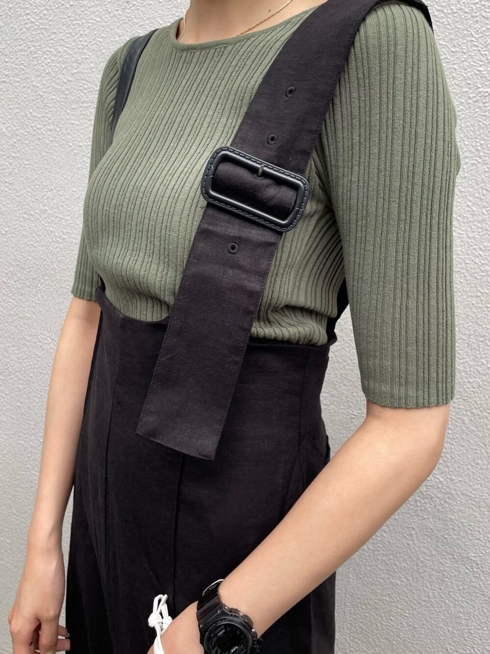 ブラック系のつなぎ/オールインワン、ホワイト系のハンドバッグ、グリーン系のニット/セーターを着用したレディースの春コーディネートの4枚目の写真