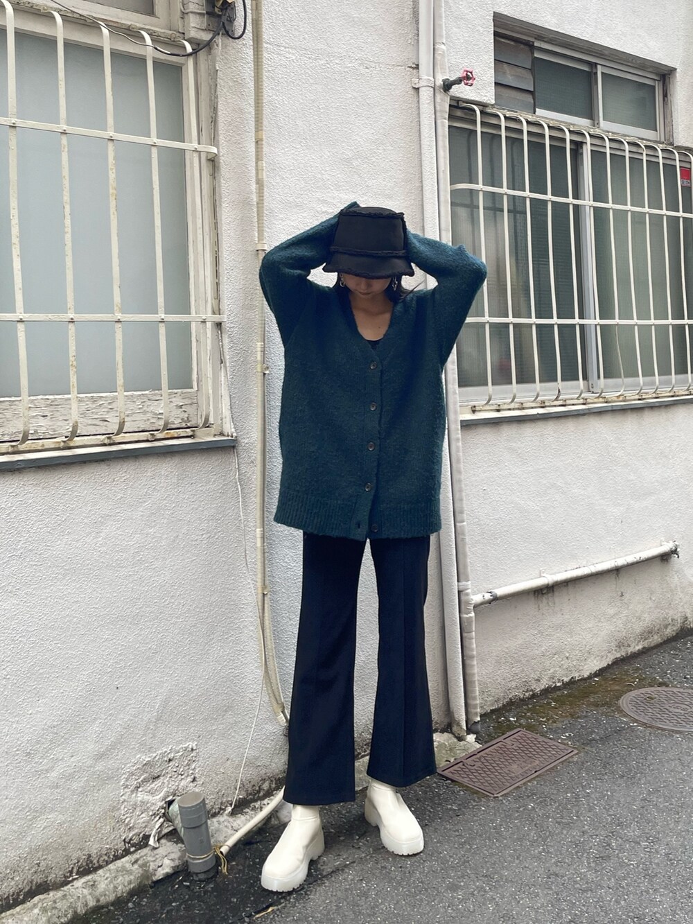 グリーン系のカーディガン/ボレロ、ブラック系のその他パンツ、ホワイト系のブーツを着用したレディースの秋コーディネートの3枚目の写真