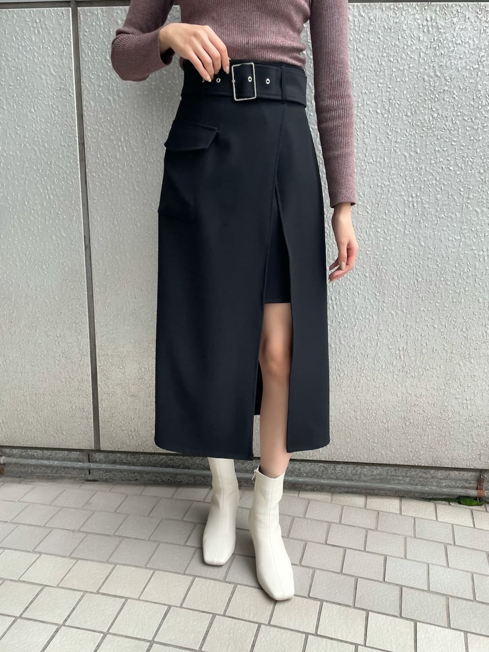 ブラック系のスカート、ブラック系のブルゾン、ホワイト系のブーツを着用したレディースの秋コーディネートの6枚目の写真