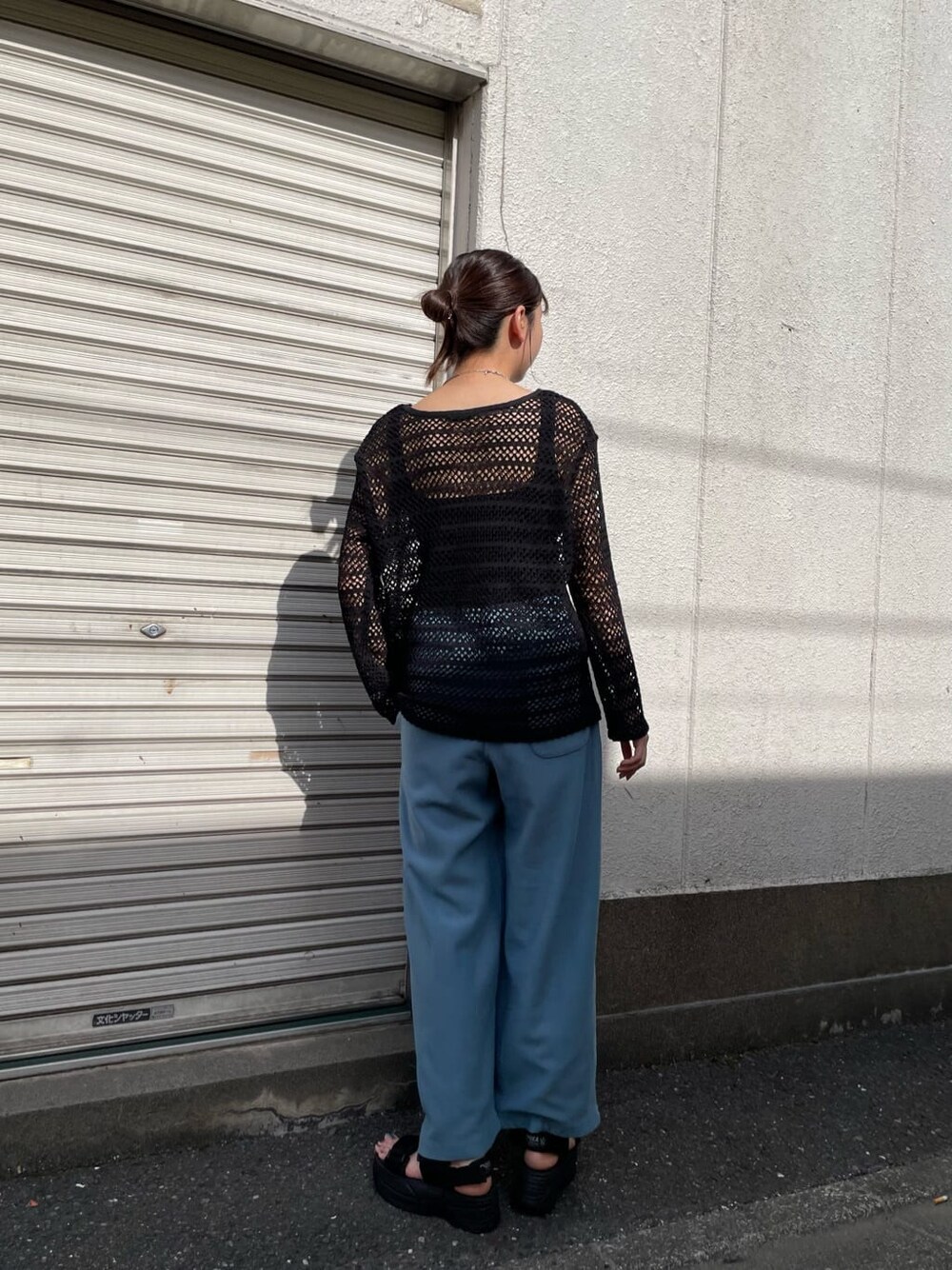 ブルー系のスウェットパンツ、ホワイト系のサンダル、ブラック系のTシャツ/カットソーを着用したレディースの春コーディネートの3枚目の写真