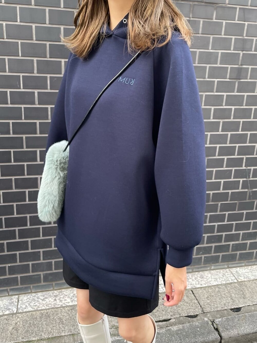 ホワイト系のブーツ、ベージュ系のショルダーバッグ、ブルー系のパーカーを着用したレディースの秋コーディネートの5枚目の写真