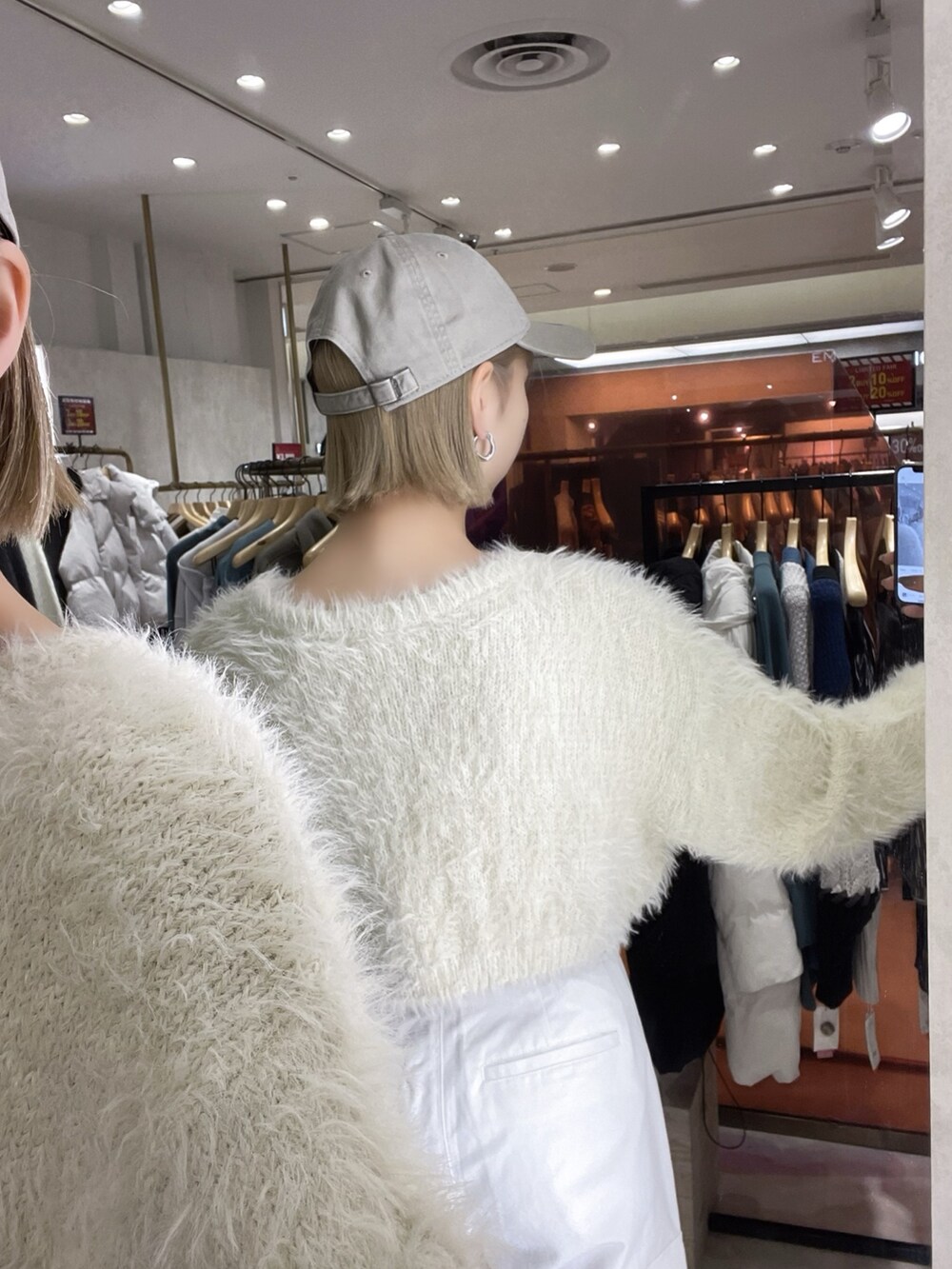 ホワイト系のカーゴパンツ、ホワイト系のニット/セーター、グレー系のキャップを着用したレディースの冬コーディネートの4枚目の写真