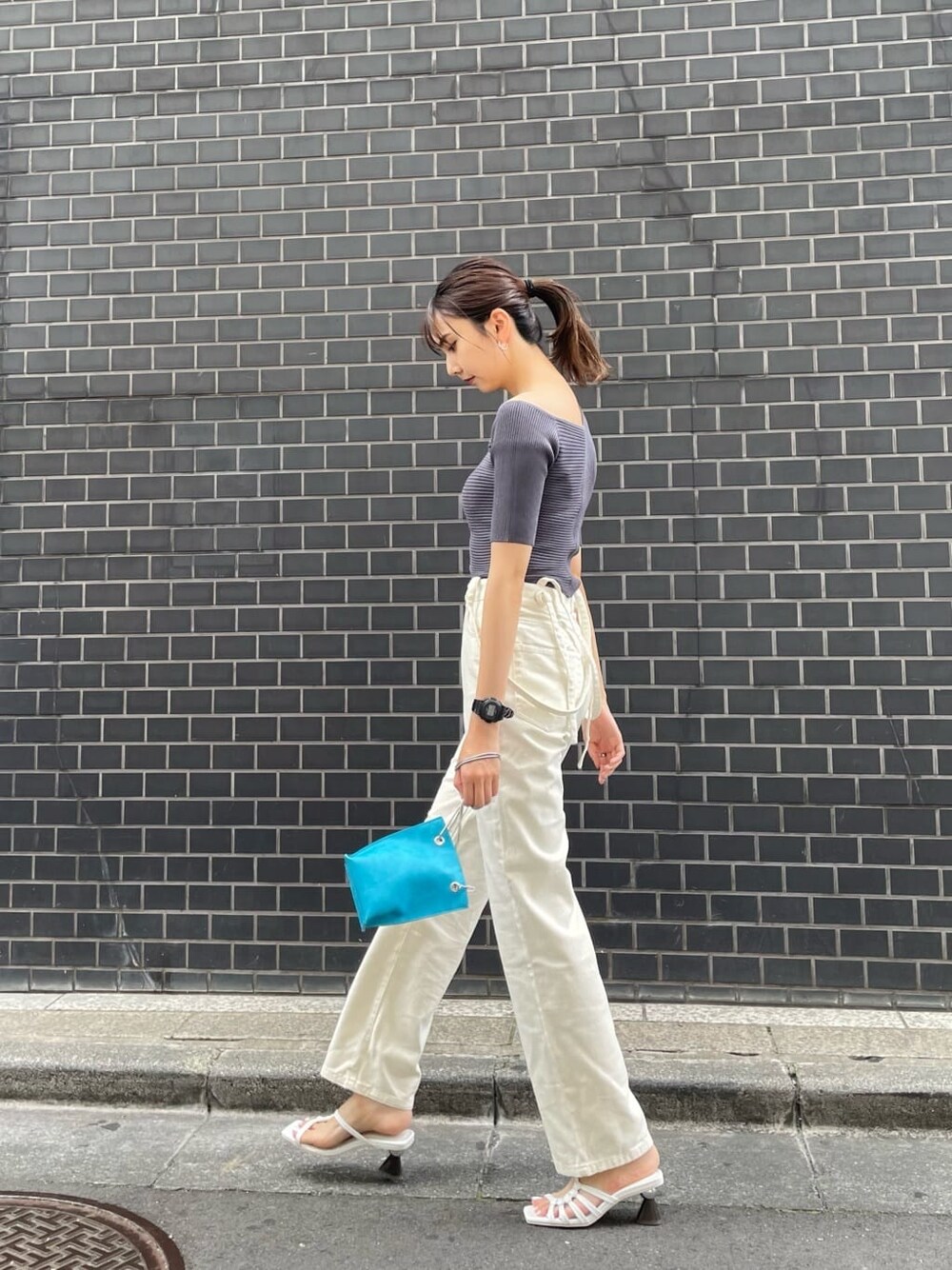 ホワイト系のデニムパンツ、ホワイト系のサンダル、グレー系のニット/セーターを着用したレディースの夏コーディネートの3枚目の写真