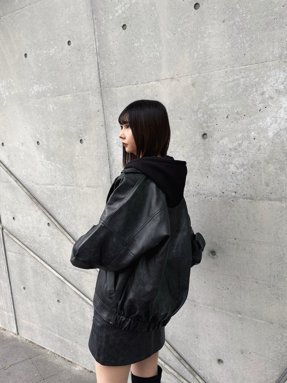 ブラック系のブルゾン、ブラック系のパーカー、ブラック系のブーツを着用したレディースの冬コーディネートの5枚目の写真