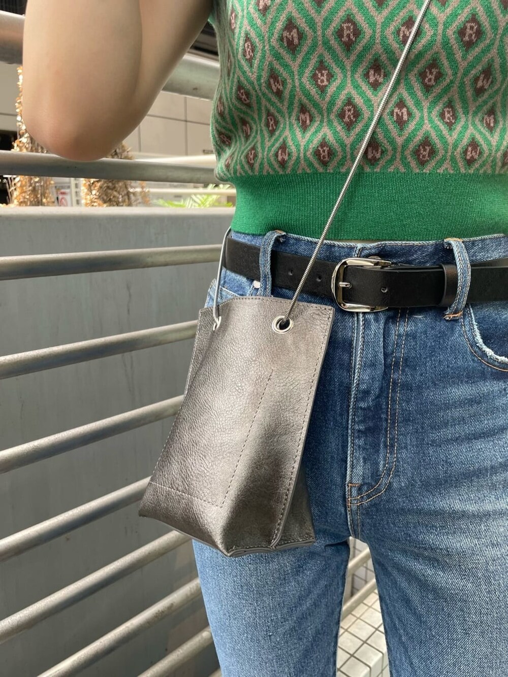 ブルー系のデニムパンツ、ブラック系のショルダーバッグ、グリーン系のニット/セーターを着用したレディースの夏コーディネートの8枚目の写真