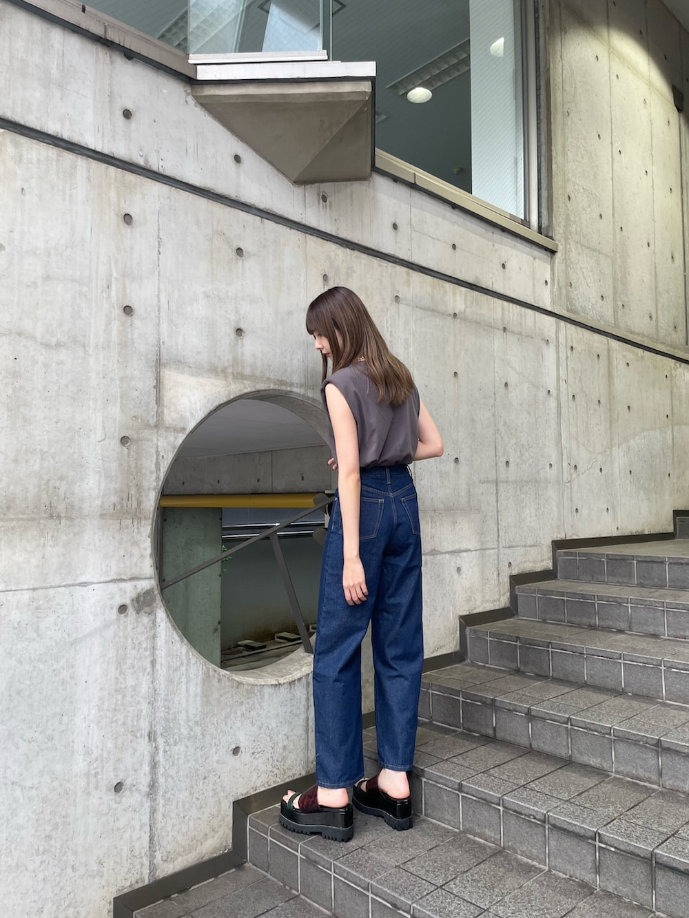 グレー系のTシャツ/カットソー、ブルー系のデニムパンツ、その他のサンダルを着用したレディースの春コーディネートの3枚目の写真