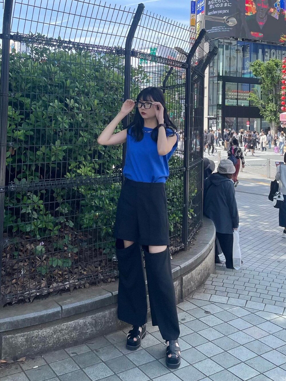 ブルー系のTシャツ/カットソー、ブラック系のスラックス、ブラック系のサンダルを着用したレディースの春コーディネートの2枚目の写真