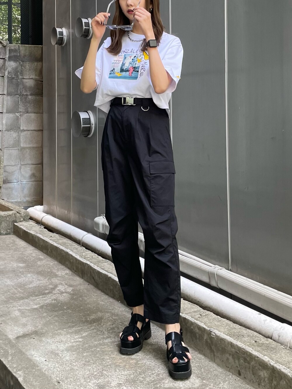 ホワイト系のTシャツ/カットソー、ブラック系のカーゴパンツ、ブラック系のサンダルを着用したレディースの春コーディネートの3枚目の写真