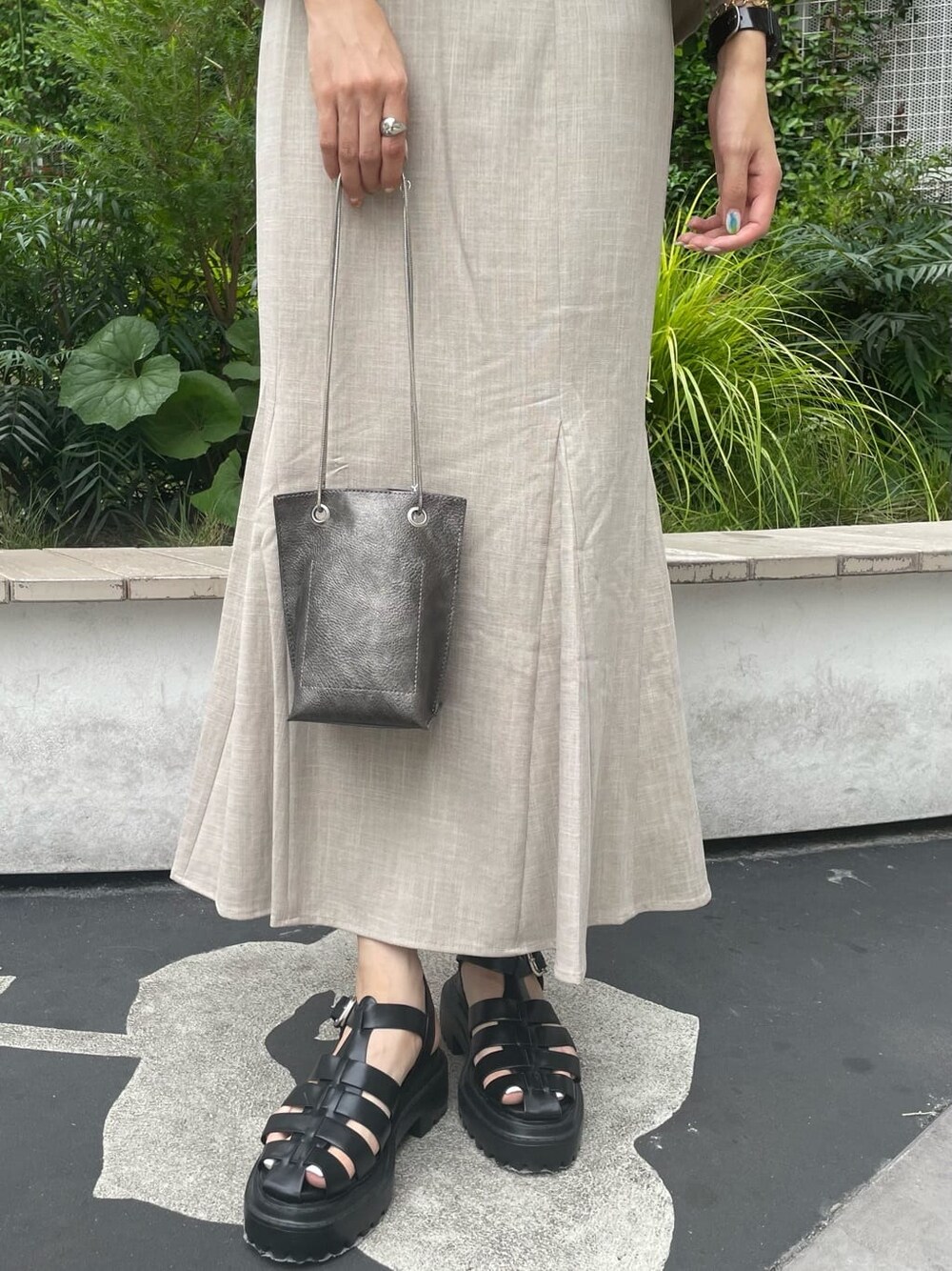 グリーン系のタンクトップ、ブラック系のサンダル、ブラック系のショルダーバッグを着用したレディースの夏コーディネートの6枚目の写真