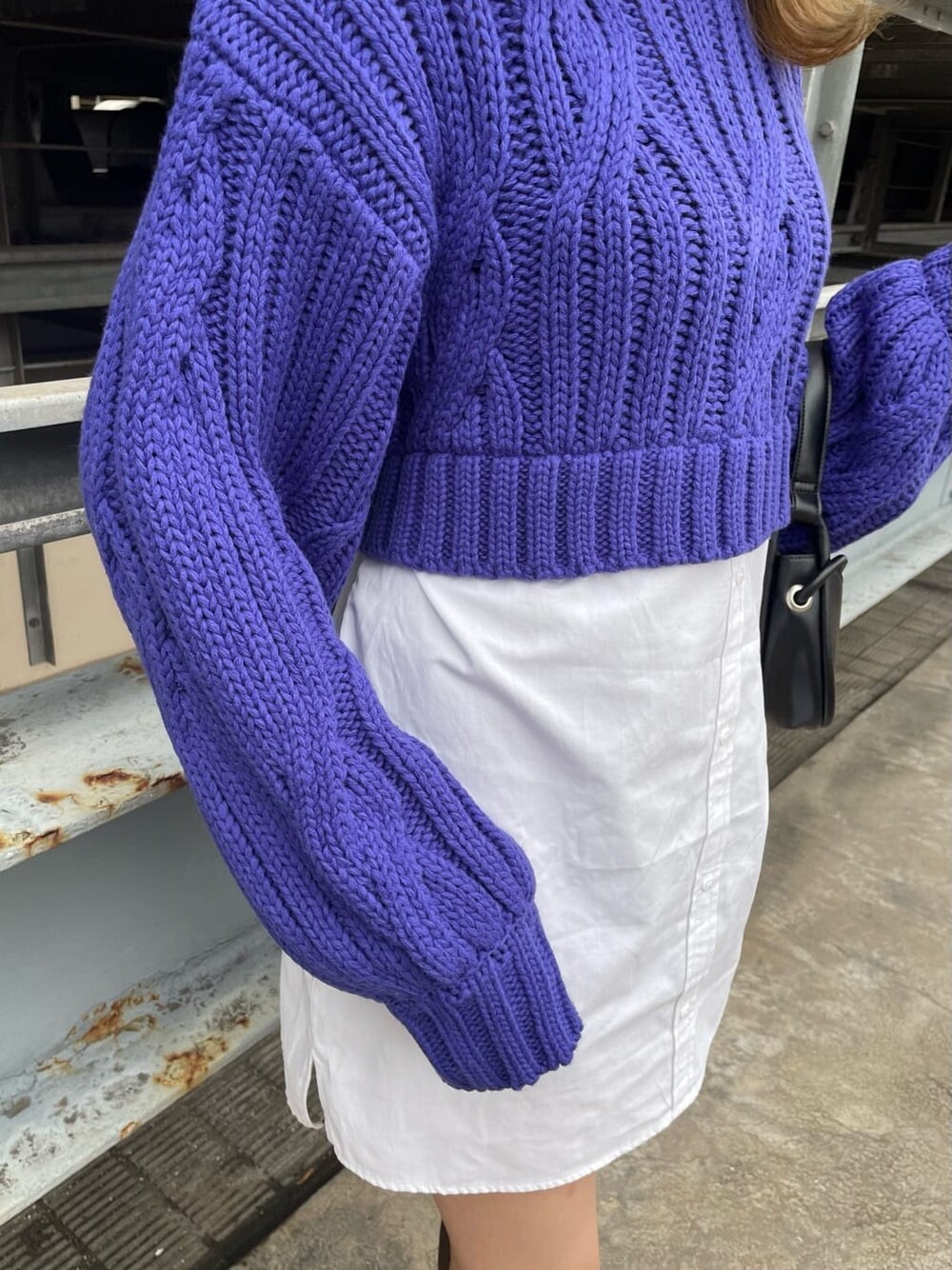 ブラウン系のムートンコート、ブラック系のハンドバッグ、ブラウン系のブーツを着用したレディースの秋コーディネートの8枚目の写真