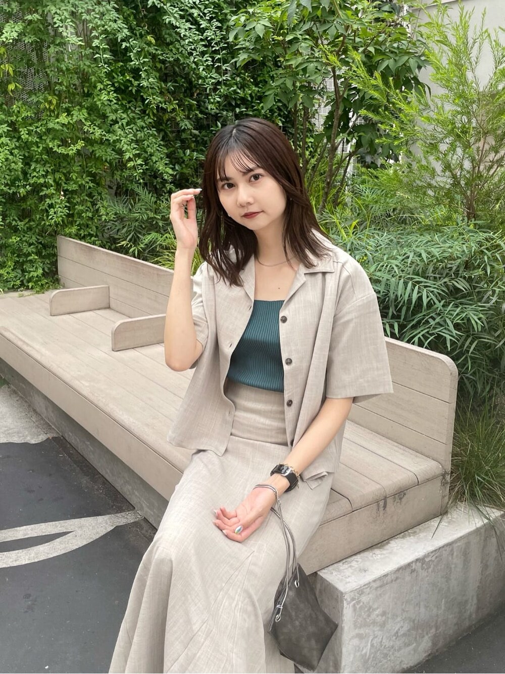 グリーン系のタンクトップ、ブラック系のサンダル、ブラック系のショルダーバッグを着用したレディースの夏コーディネートの4枚目の写真