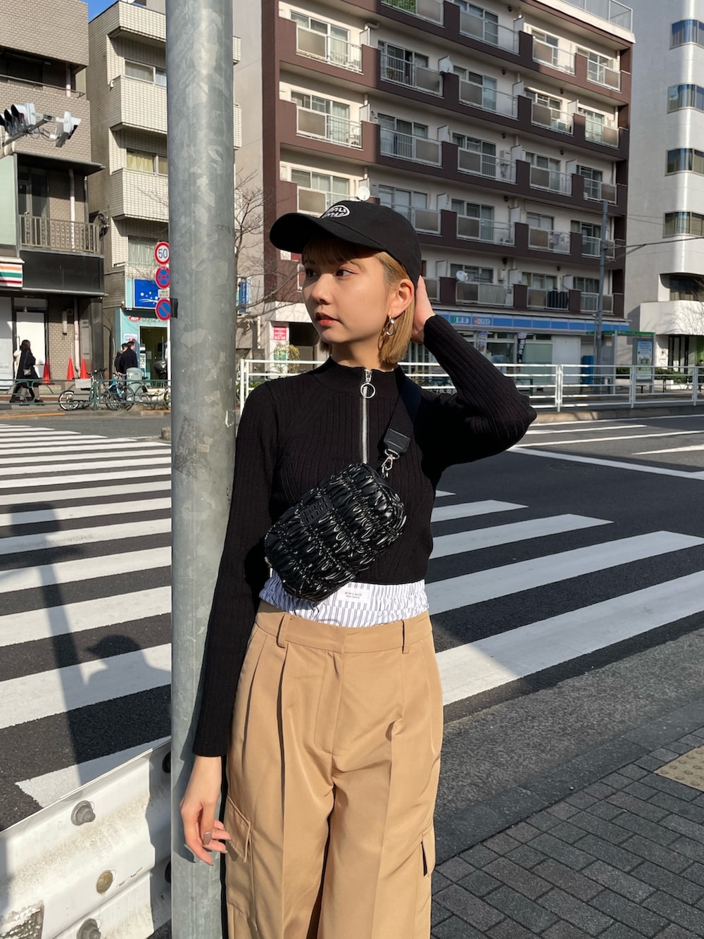 ベージュ系のその他パンツ、ブラック系のショルダーバッグ、ブラック系のニット/セーターを着用したレディースの冬コーディネートの2枚目の写真