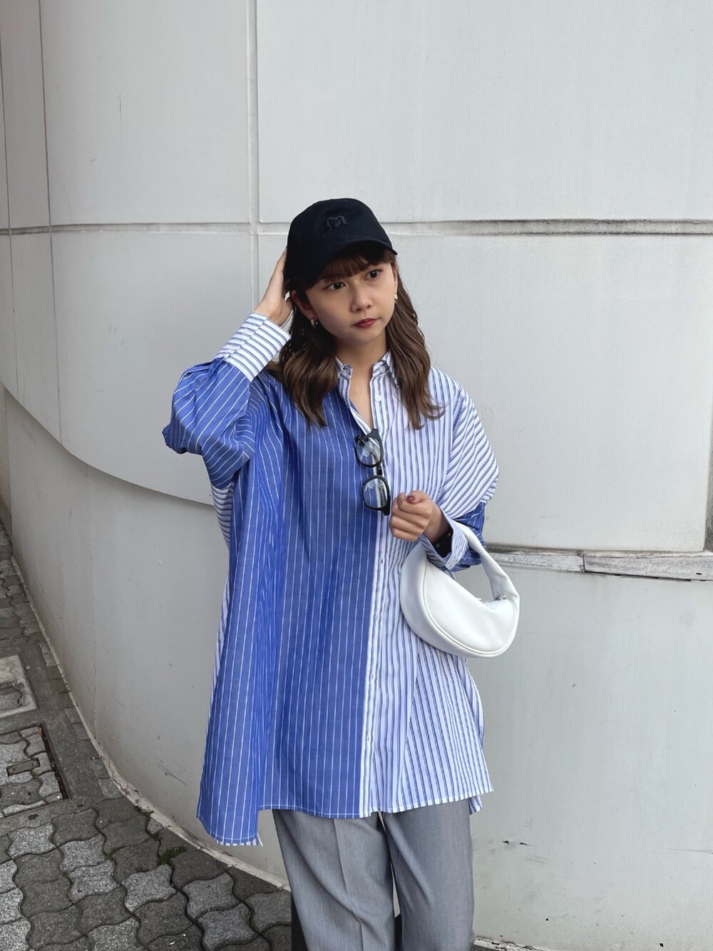 ブルー系のシャツ/ブラウス、ホワイト系のハンドバッグ、グレー系のスラックスを着用したレディースの冬コーディネートの4枚目の写真