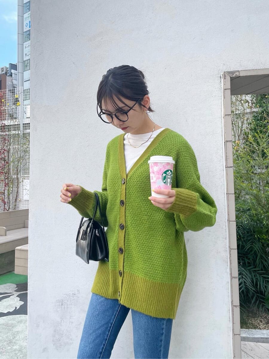 ブラック系のブーツ、ブルー系のデニムパンツ、ブラック系のハンドバッグを着用したレディースの春コーディネートの4枚目の写真