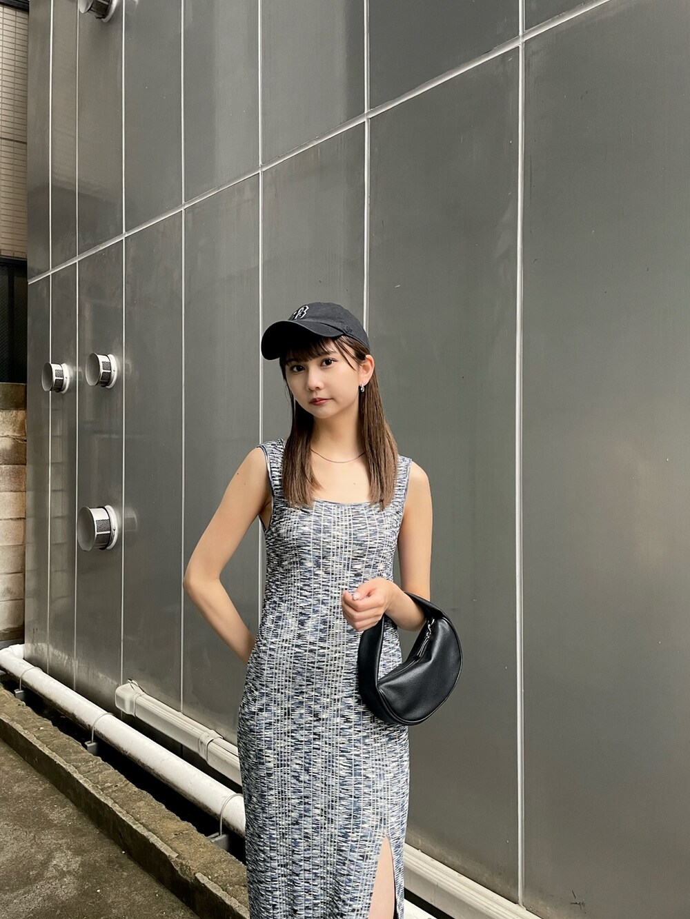 ブルー系のワンピース、ブラック系のサンダル、ブラック系のハンドバッグを着用したレディースの春コーディネートの2枚目の写真