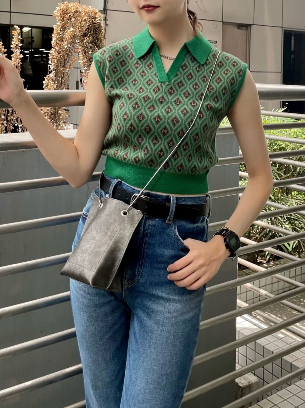 ブルー系のデニムパンツ、ブラック系のショルダーバッグ、グリーン系のニット/セーターを着用したレディースの夏コーディネートの5枚目の写真