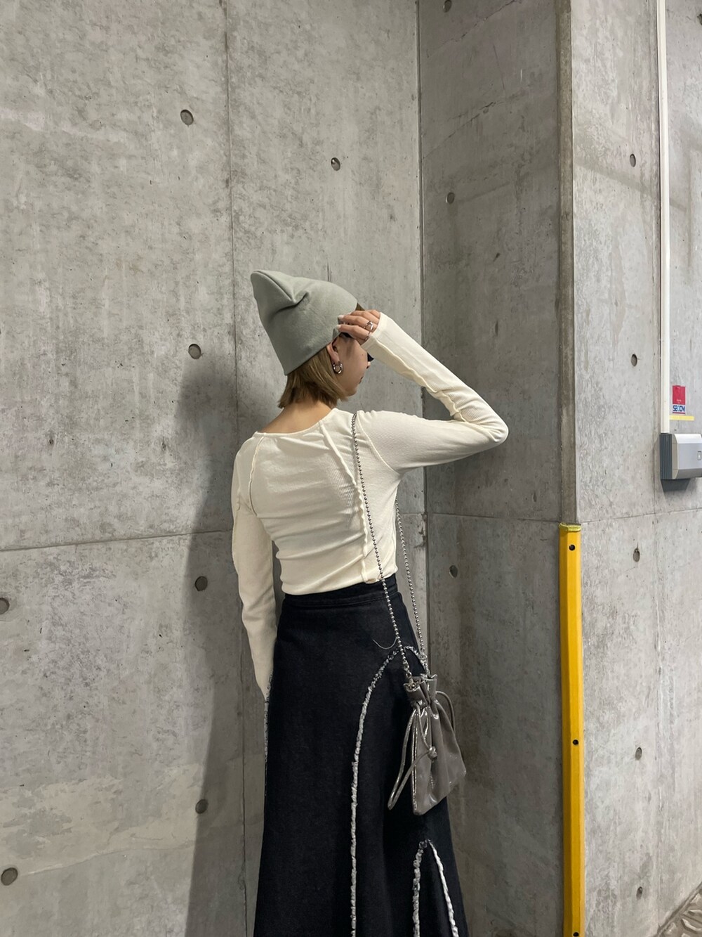 ホワイト系のTシャツ/カットソー、ホワイト系のTシャツ/カットソー、ブラック系のデニムスカートを着用したレディースの冬コーディネートの4枚目の写真