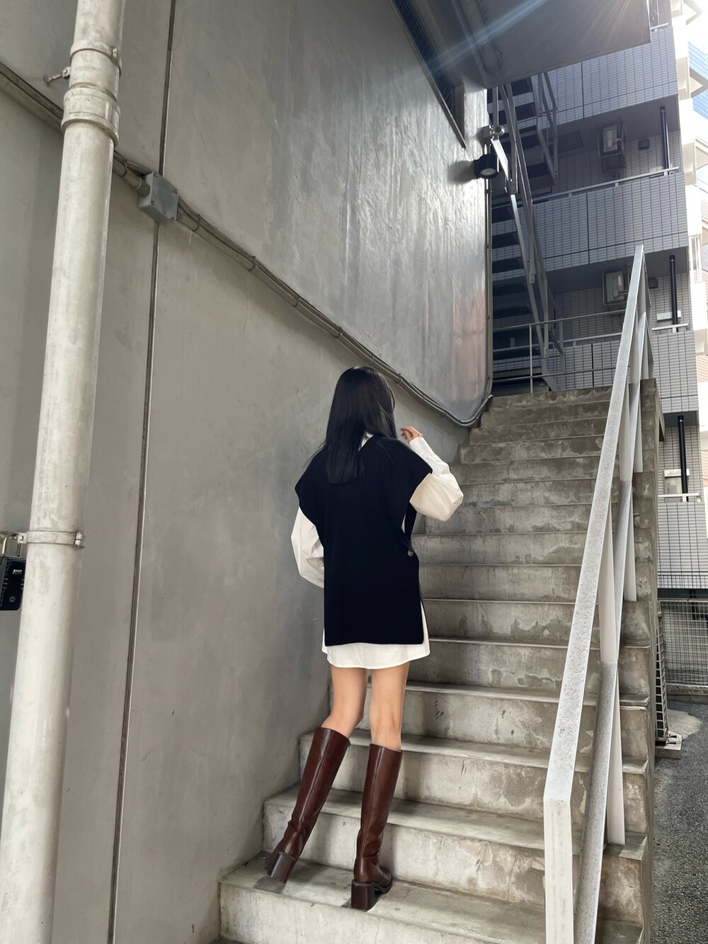 ブラック系のワンピース、ブラウン系のブーツを着用したレディースの夏コーディネートの4枚目の写真