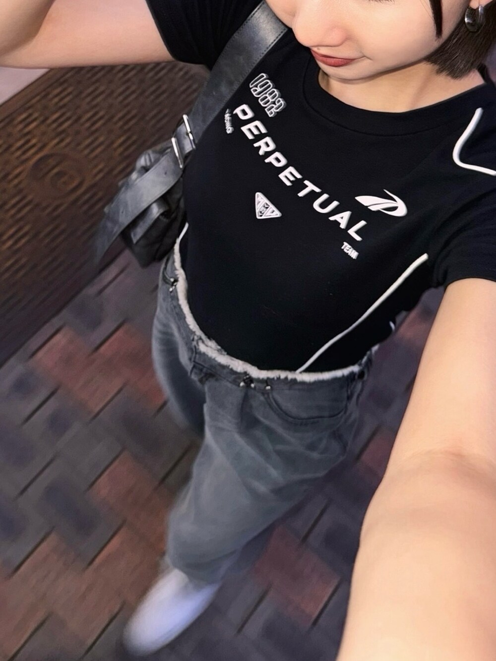 ブラック系のTシャツ/カットソー、ブラック系のデニムパンツを着用したレディースの夏コーディネートの2枚目の写真