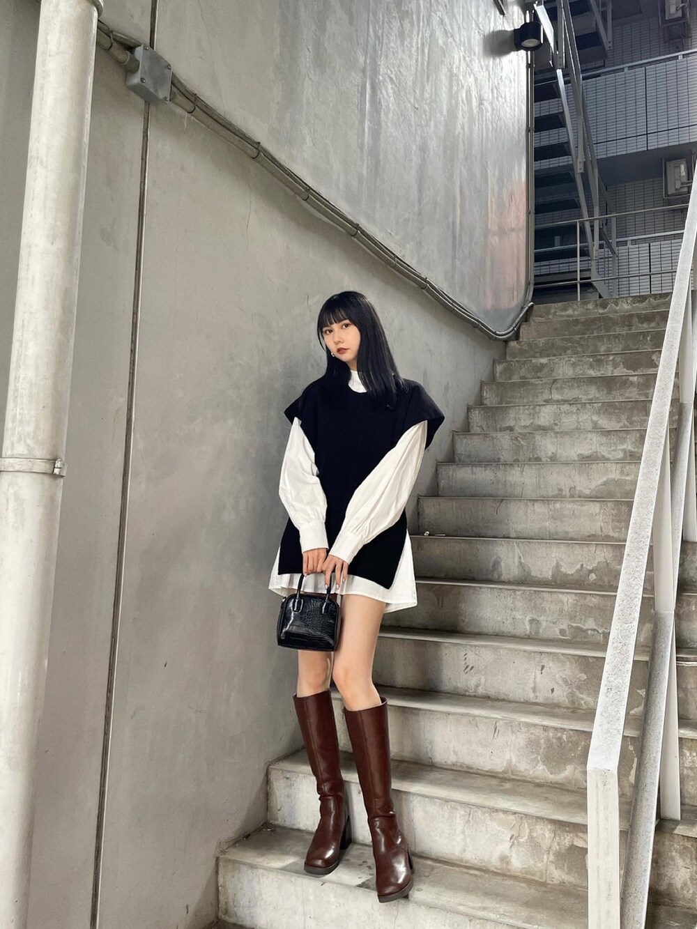 ブラック系のワンピース、ブラウン系のブーツを着用したレディースの夏コーディネートの2枚目の写真
