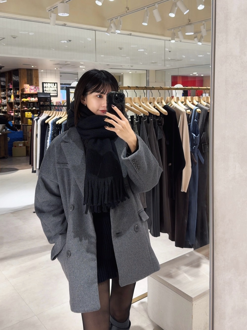 グレー系のテーラードジャケット、ブラック系のマフラーを着用したレディースの冬コーディネートの4枚目の写真