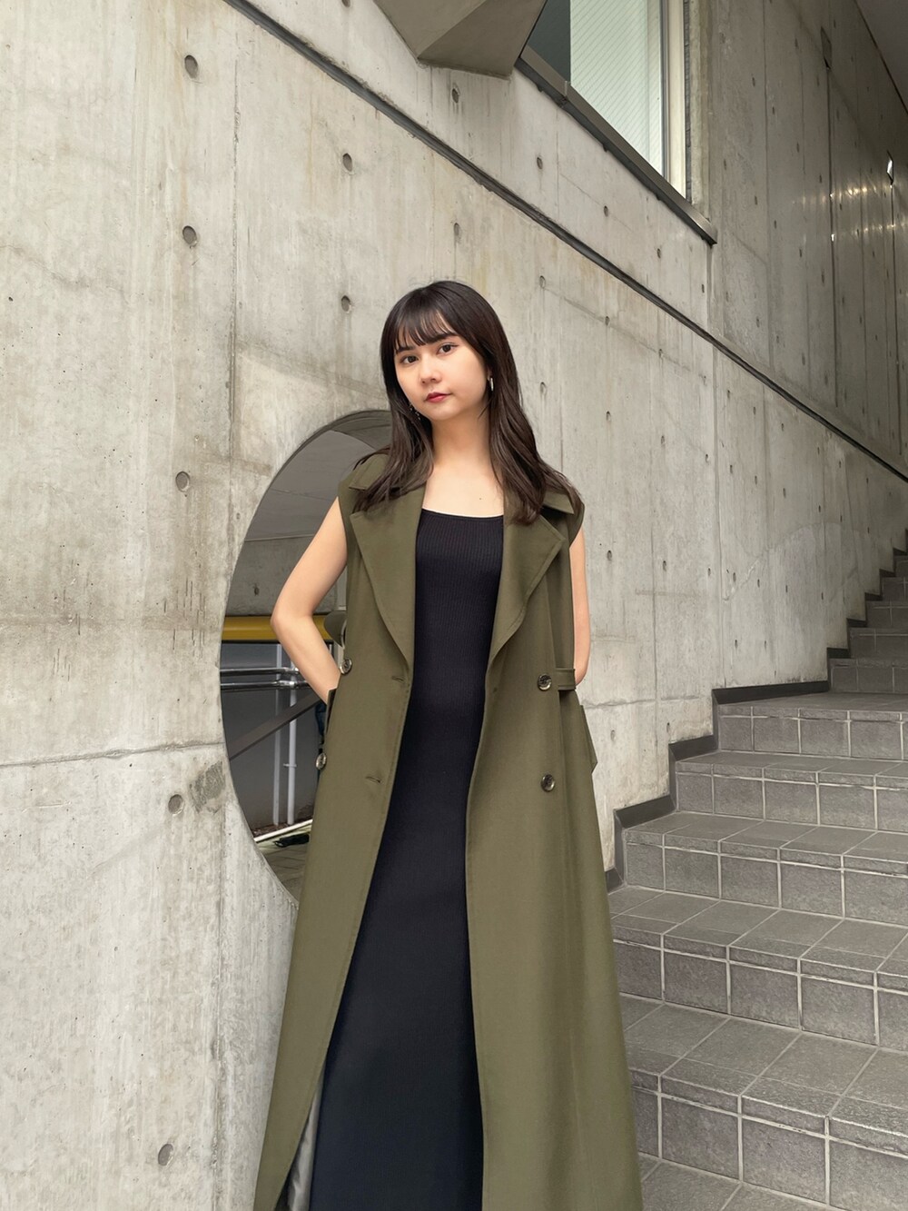 グリーン系のトレンチコートを着用したレディースの夏コーディネートの9枚目の写真