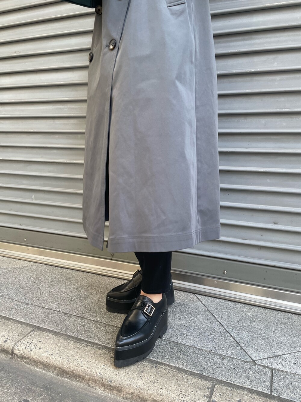 ブルー系のハンドバッグ、グレー系のトレンチコート、ブラック系のニット/セーターを着用したレディースの冬コーディネートの7枚目の写真