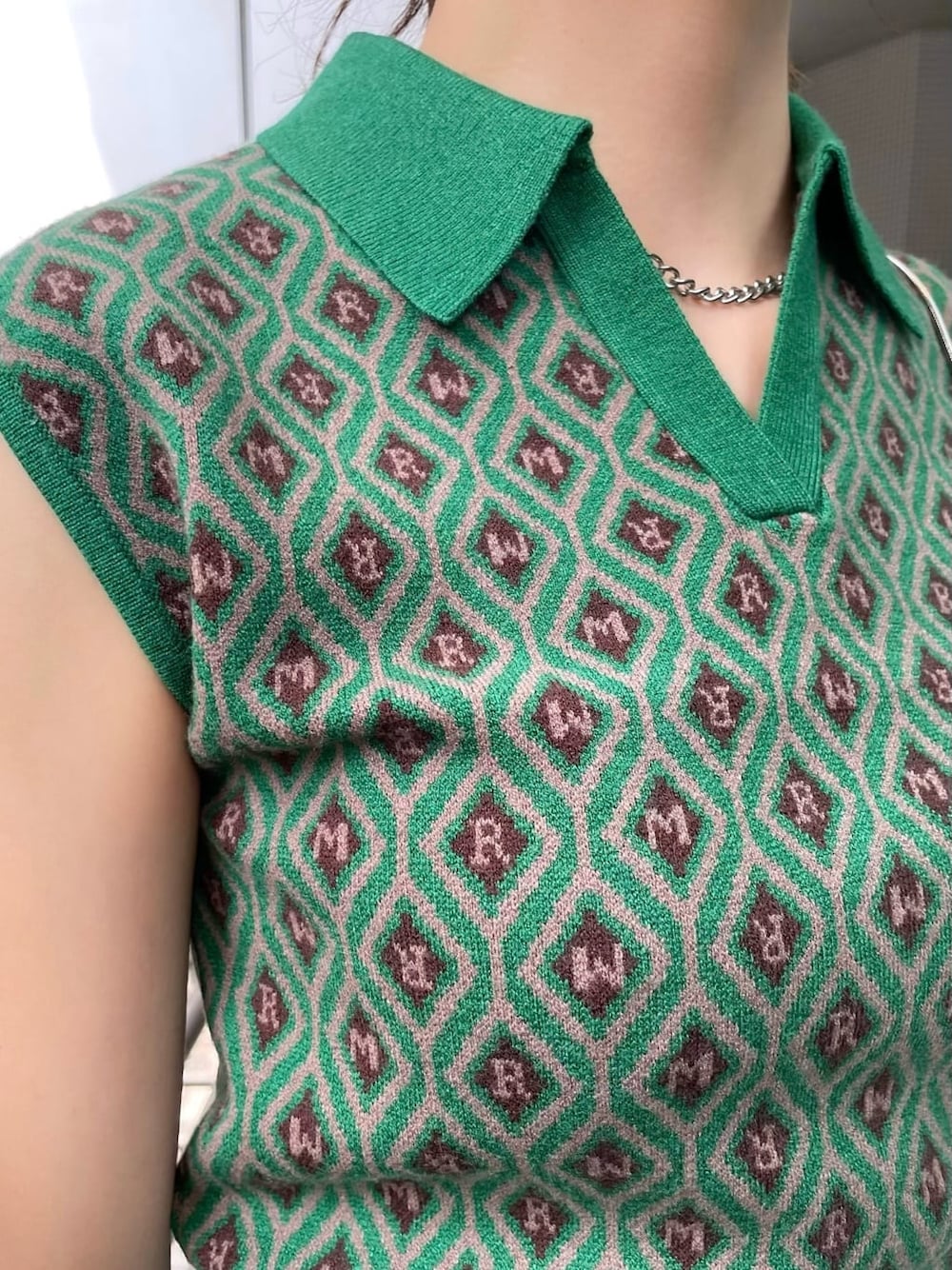 ブルー系のデニムパンツ、ブラック系のショルダーバッグ、グリーン系のニット/セーターを着用したレディースの夏コーディネートの6枚目の写真