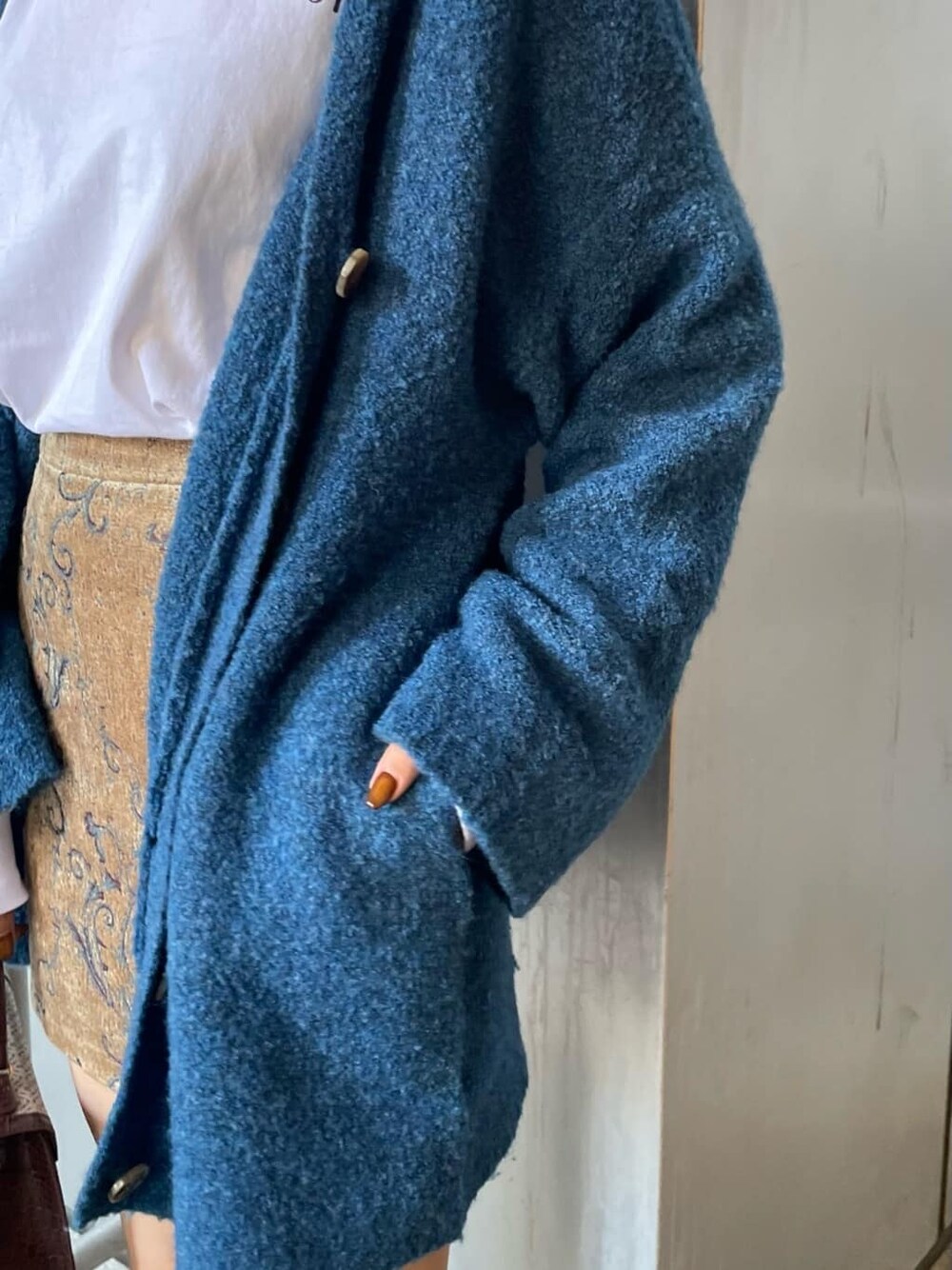 ホワイト系のTシャツ/カットソー、ブラウン系のスカート、ブルー系のカーディガン/ボレロを着用したレディースの秋コーディネートの7枚目の写真