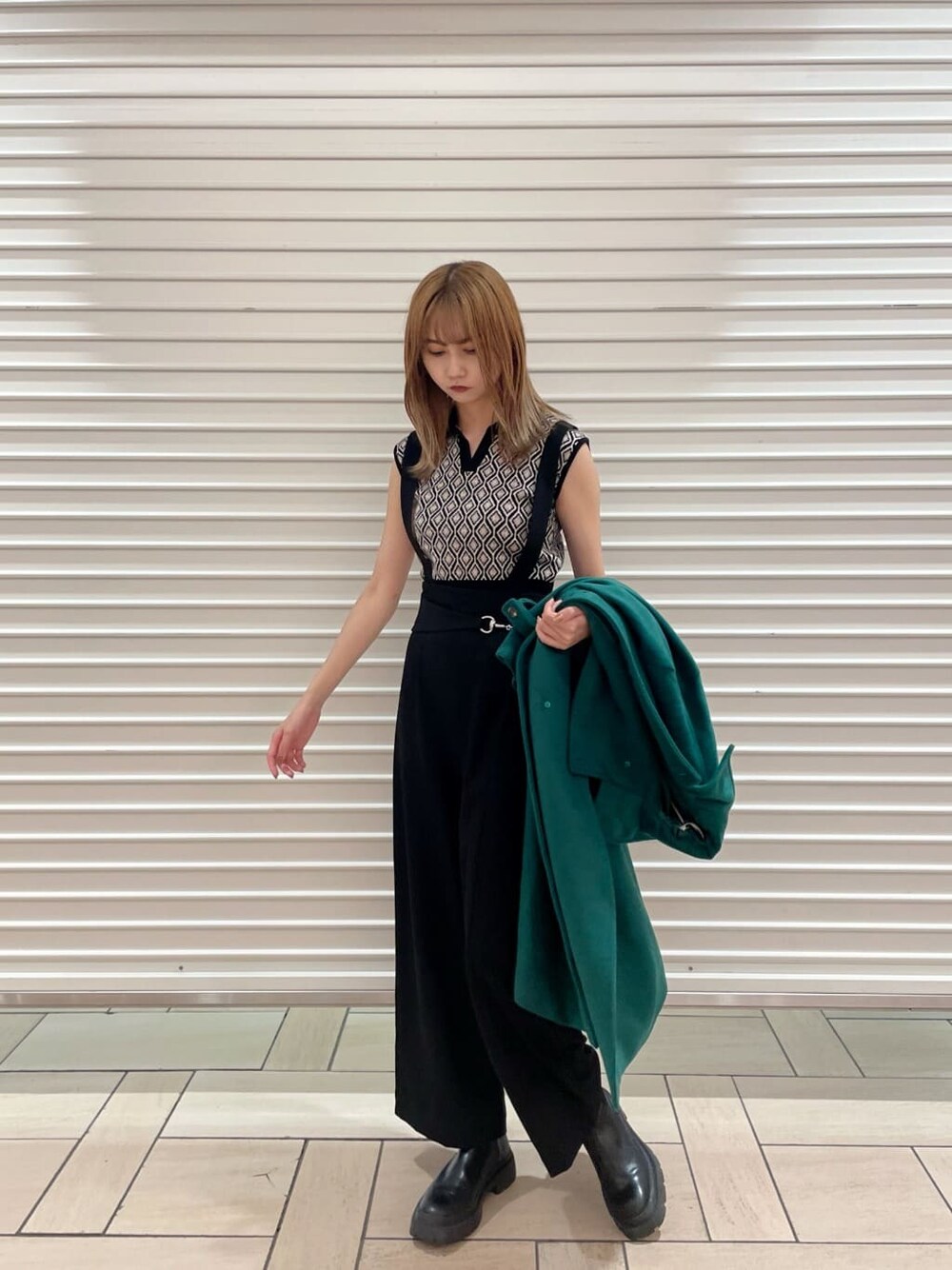 ブラック系のスラックス、ブラック系のニット/セーター、グリーン系のステンカラーコートを着用したレディースの夏コーディネートの4枚目の写真