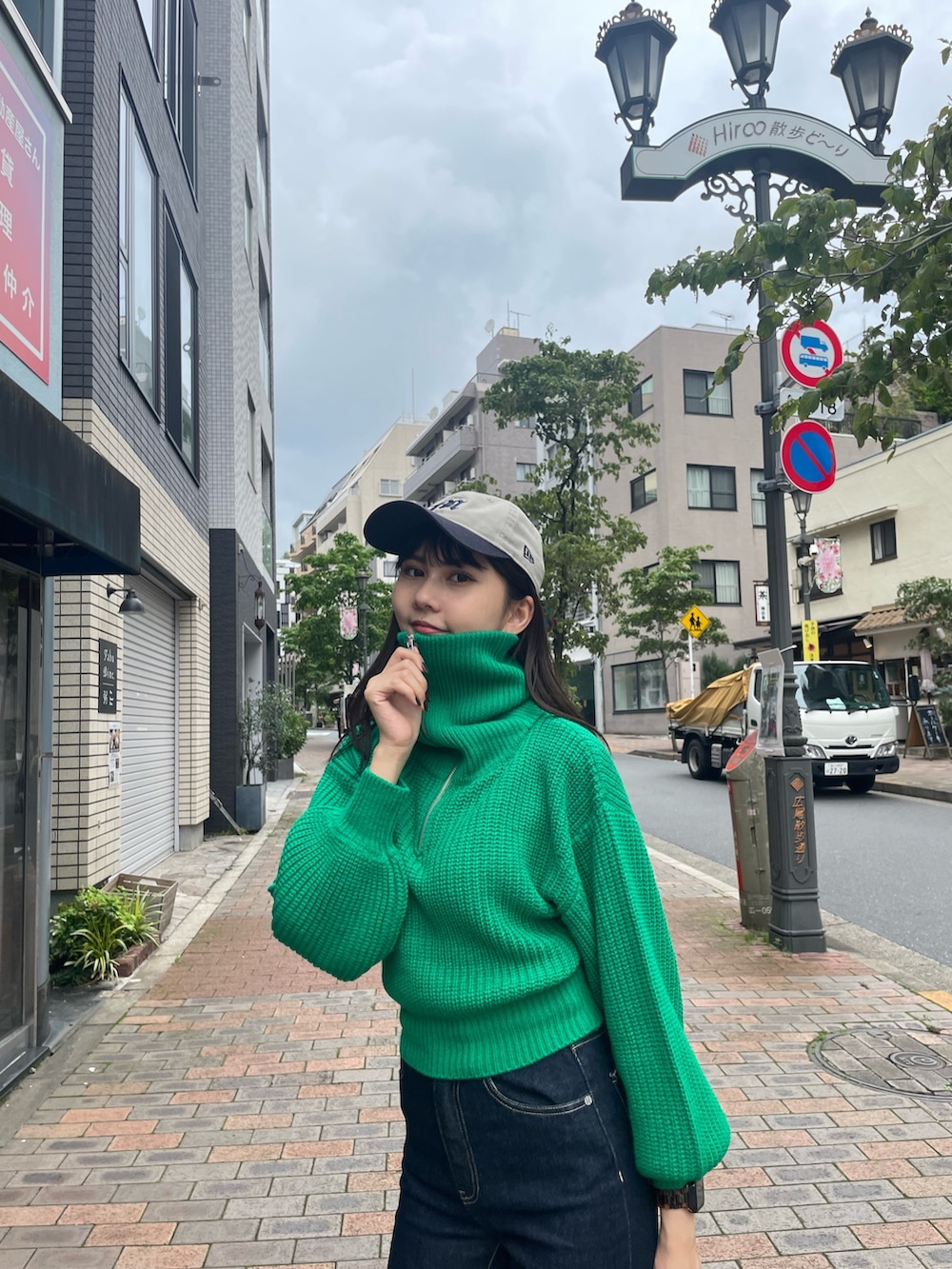 グリーン系のニット/セーター、ホワイト系のブーツを着用したレディースの夏コーディネートの4枚目の写真