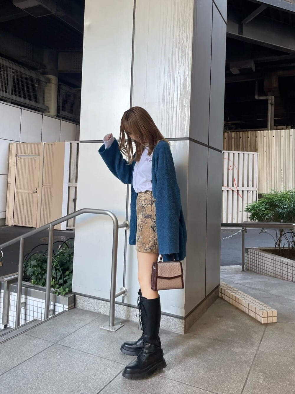 ホワイト系のTシャツ/カットソー、ブラウン系のスカート、ブルー系のカーディガン/ボレロを着用したレディースの秋コーディネートの3枚目の写真