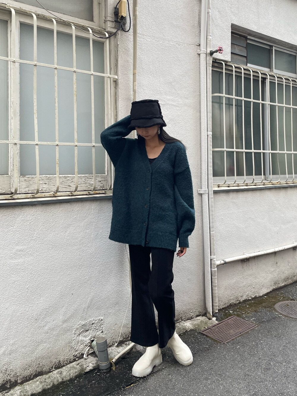 グリーン系のカーディガン/ボレロ、ブラック系のその他パンツ、ホワイト系のブーツを着用したレディースの秋コーディネートの2枚目の写真