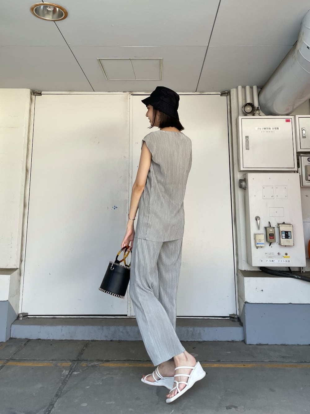 グレー系のスウェットパンツ、ブラック系のハンドバッグ、ホワイト系のサンダルを着用したレディースの夏コーディネートの3枚目の写真