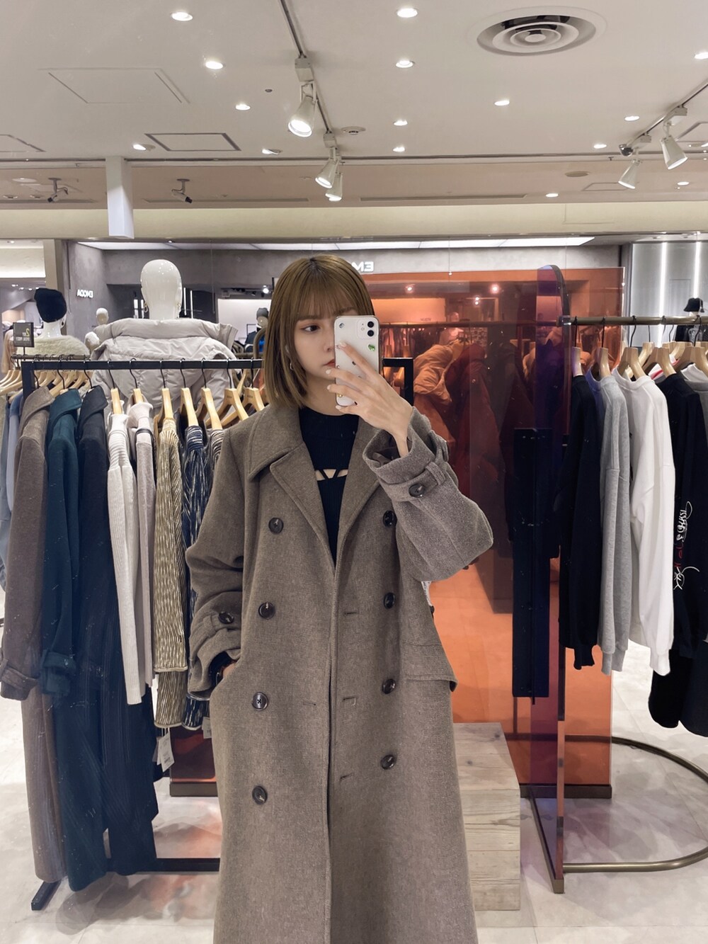 ブラウン系のチェスターコート、ブラック系のニット/セーター、ブラック系のその他パンツを着用したレディースの冬コーディネートの2枚目の写真