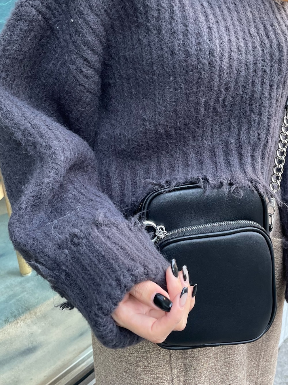 グレー系のニット/セーター、ブラウン系のスカート、ブラック系のブーツを着用したレディースの秋コーディネートの3枚目の写真