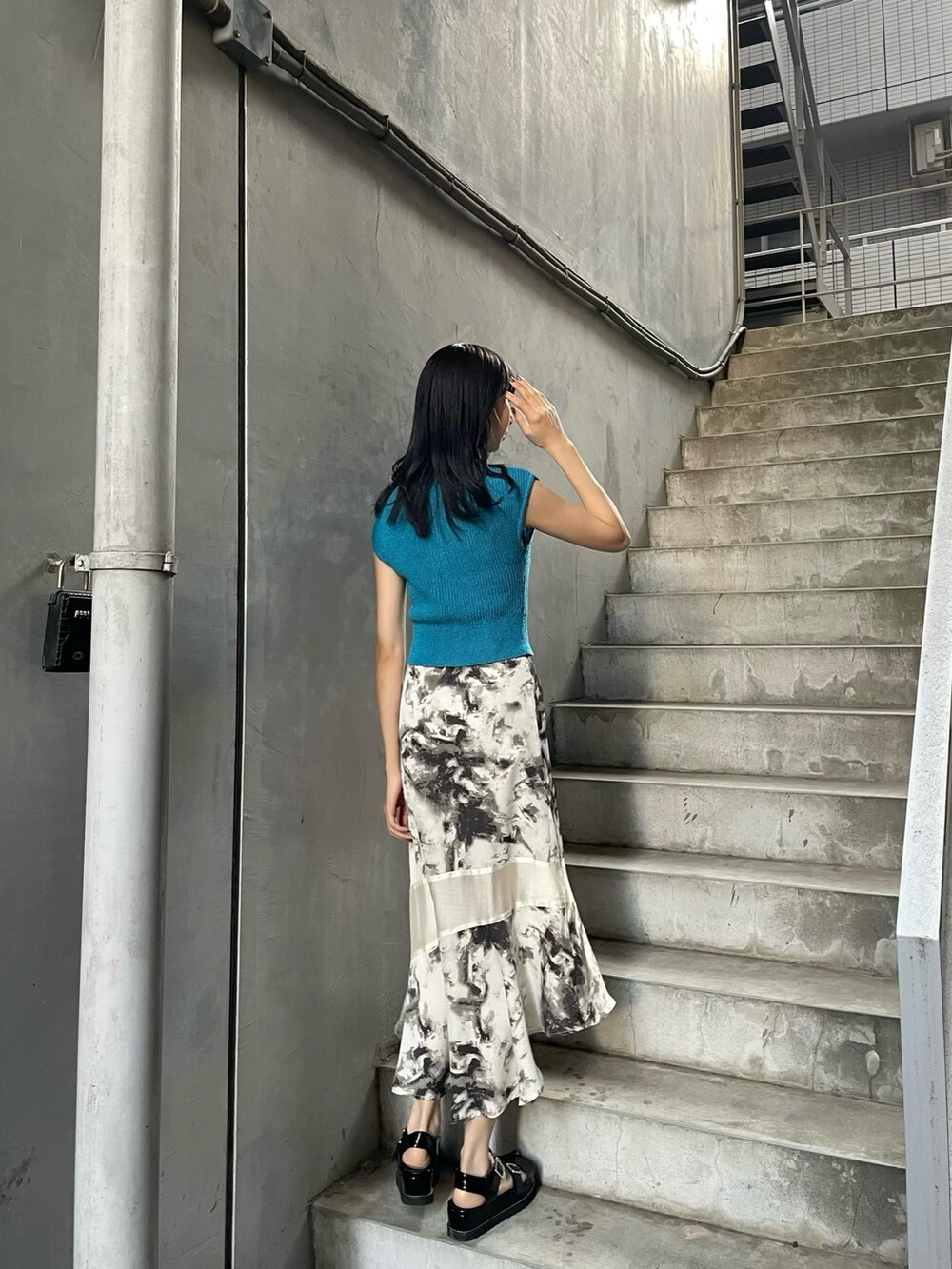 ブルー系のニット/セーター、その他のスカート、ブラック系のサンダルを着用したレディースの春コーディネートの3枚目の写真