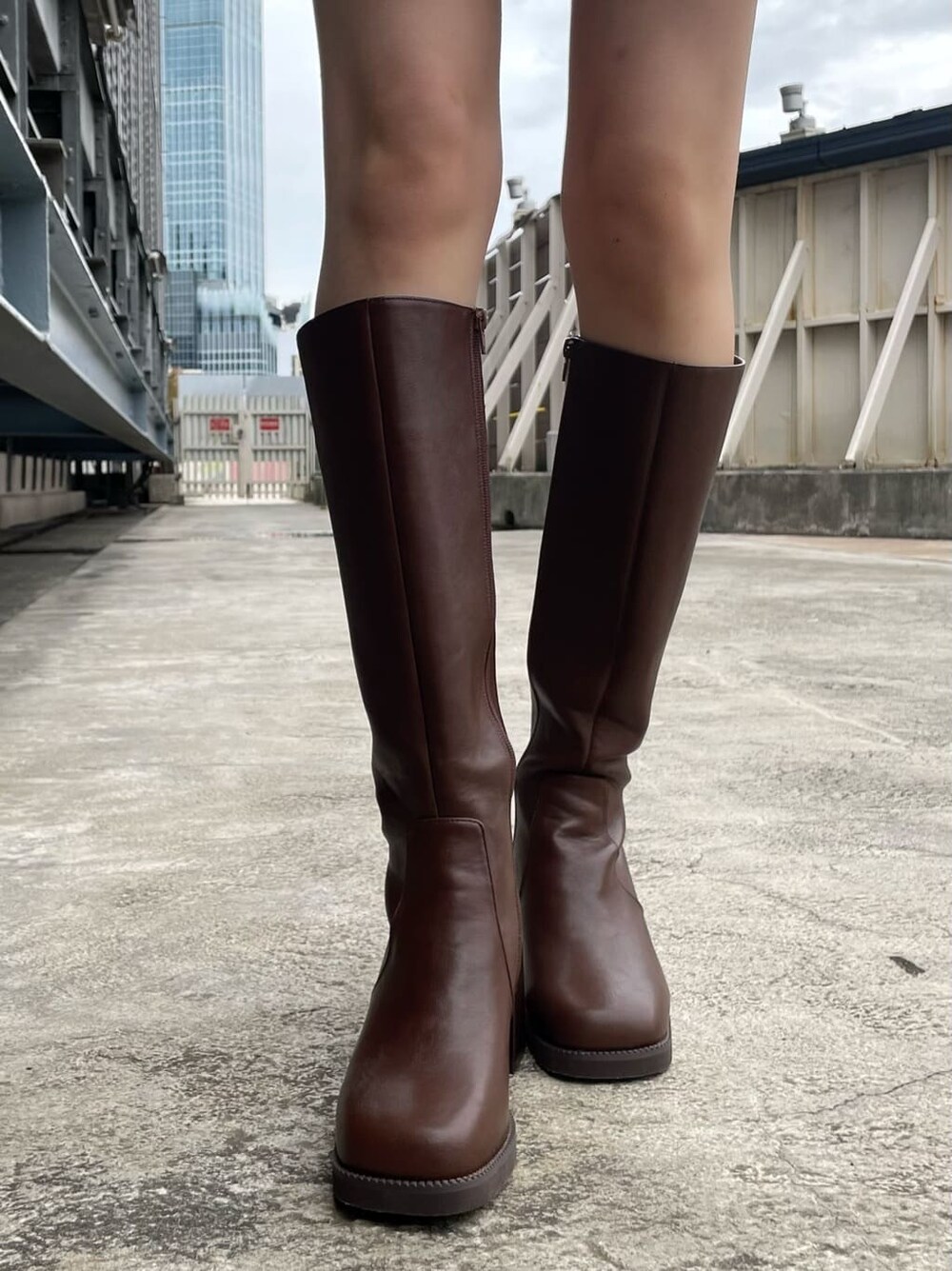 ブラウン系のムートンコート、ブラック系のハンドバッグ、ブラウン系のブーツを着用したレディースの秋コーディネートの10枚目の写真