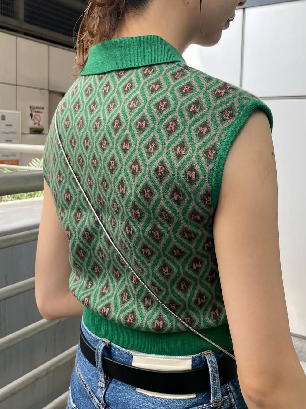 ブルー系のデニムパンツ、ブラック系のショルダーバッグ、グリーン系のニット/セーターを着用したレディースの夏コーディネートの7枚目の写真