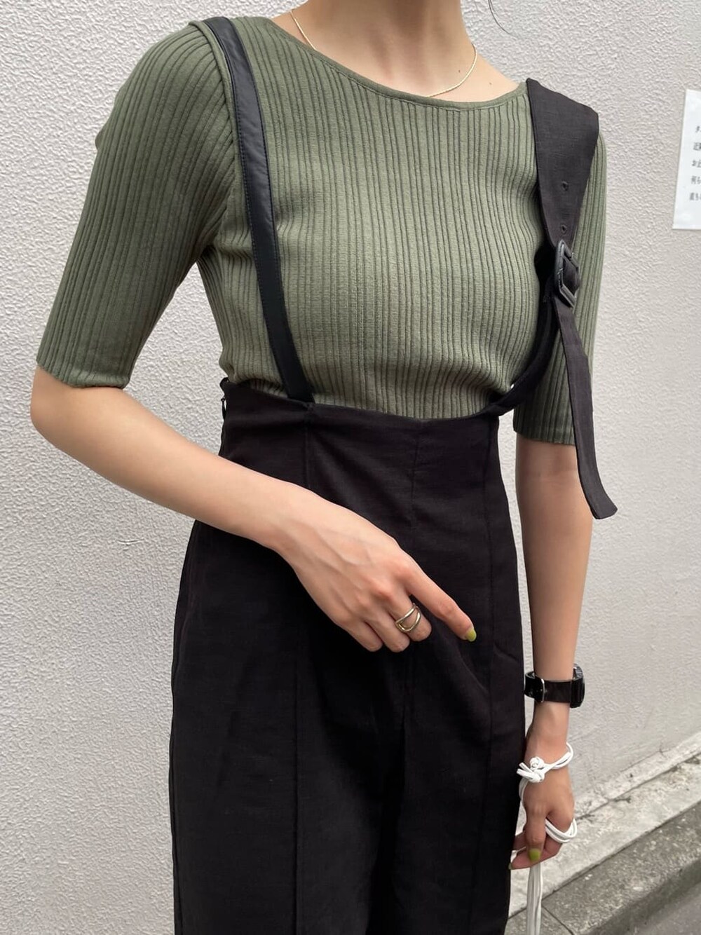 ブラック系のつなぎ/オールインワン、ホワイト系のハンドバッグ、グリーン系のニット/セーターを着用したレディースの春コーディネートの5枚目の写真