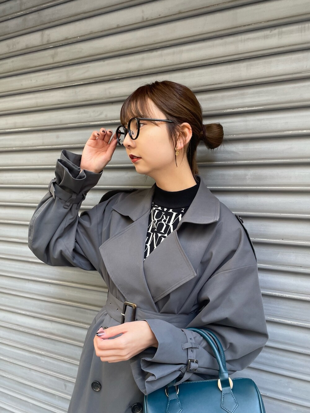 ブルー系のハンドバッグ、グレー系のトレンチコート、ブラック系のニット/セーターを着用したレディースの冬コーディネートの5枚目の写真