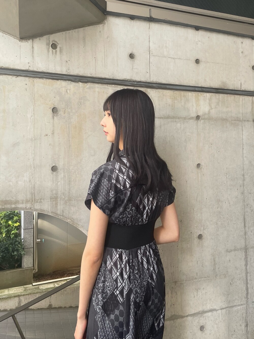 ブラック系のワンピース、ブラック系のハンドバッグ、ブラック系のサンダルを着用したレディースの春コーディネートの4枚目の写真