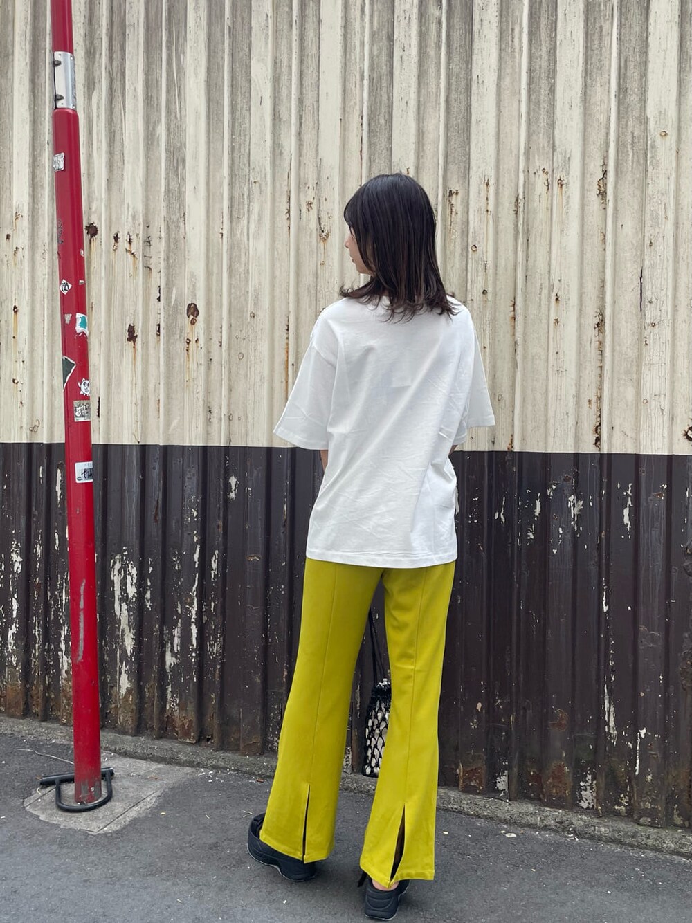 ブラック系のサンダル、ブラック系のハンドバッグ、ホワイト系のTシャツ/カットソーを着用したレディースの春コーディネートの3枚目の写真