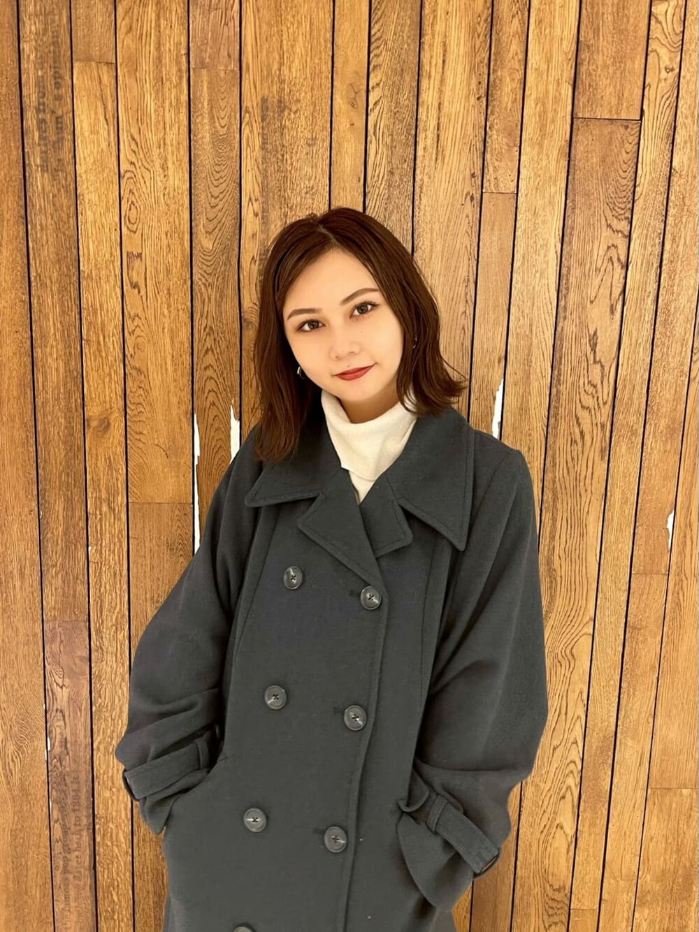 ブラック系のブーツ、ブラック系のその他パンツ、ホワイト系のハンドバッグを着用したレディースの秋コーディネートの4枚目の写真