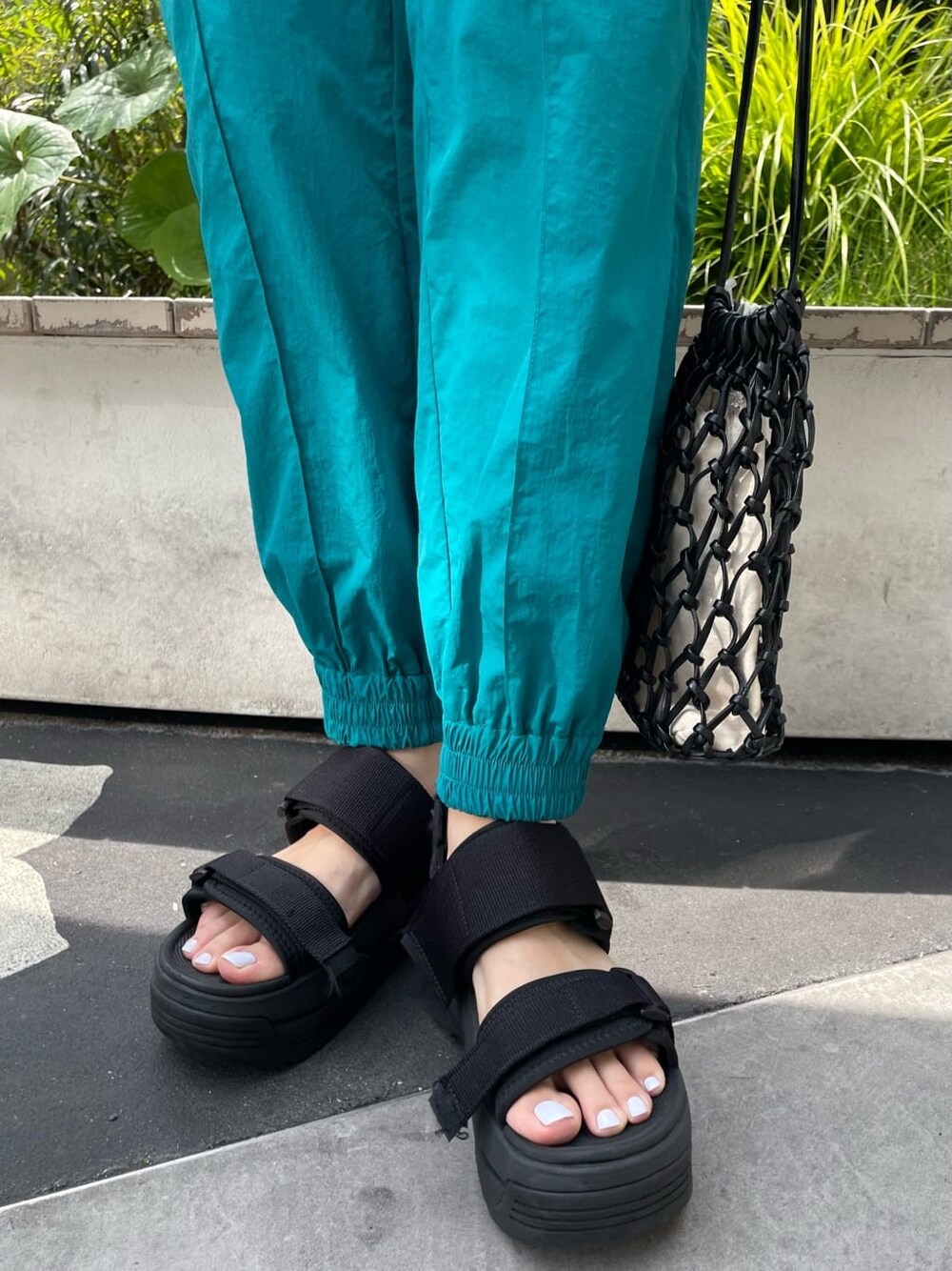 ブラック系のハンドバッグ、ホワイト系のシャツ/ブラウス、ブラック系のサンダルを着用したレディースの夏コーディネートの7枚目の写真